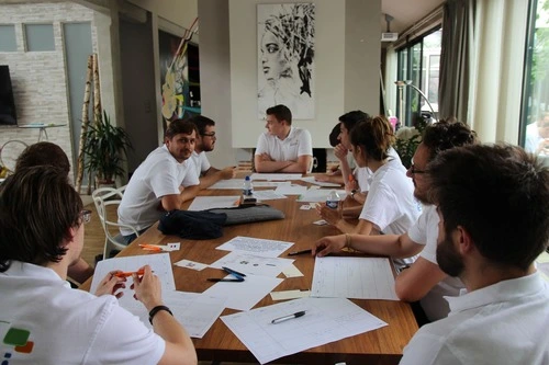 Réunion de travail autour d’une table avec documents et échanges collaboratifs.